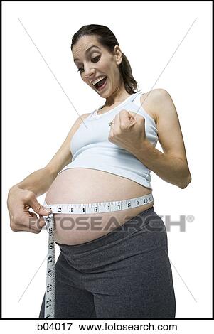 Pregnant woman measuring belly View Large Photo Image Stock Photo - Pregnant woman measuring belly. Fotosearch