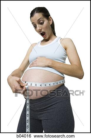 Pregnant woman measuring belly View Large Photo Image Stock Photograph - Pregnant woman measuring belly. Fotosearch