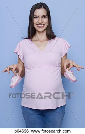 Pregnant woman with baby shoes View Large Photo Image Stock Photograph - Pregnant woman with baby shoes. Fotosearch