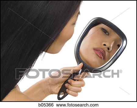 Stock Photograph - Reflection of woman in hand mirror. Fotosearch