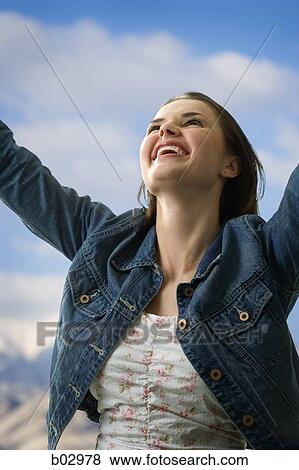 Stock Photo - Smiling woman with raised arms. Fotosearch