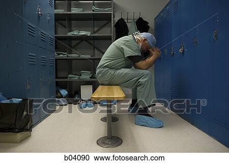 Surgeon sitting in locker room with head in hands View Large Photo Image Stock Image - Surgeon sitting in locker room with head in hands. Fotosearch