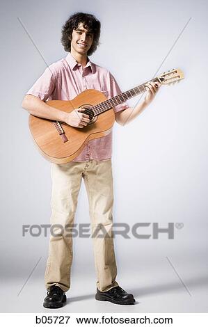 Stock Photo - Teenage boy playing guitar. Fotosearch