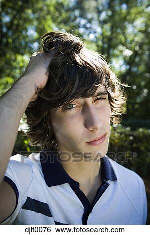 Stock Photograph - Teenage boy rubbing head. Fotosearch