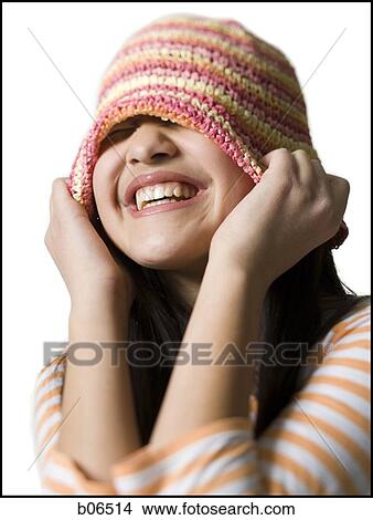 Teenage girl smiling and putting on a hat View Large Photo Image Picture - Teenage girl smiling and putting on a hat. Fotosearch