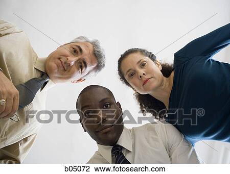 Three businesspeople looking down View Large Photo Image Stock Image - Three businesspeople looking down. Fotosearch