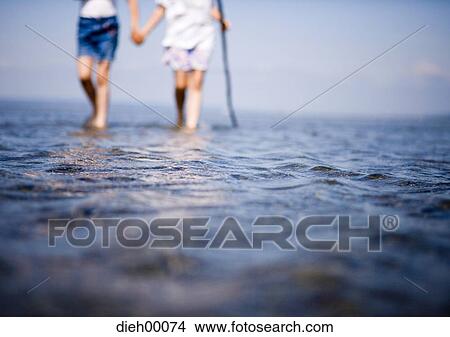 Two female children wading View Large Photo Image Picture - Two female children wading. Fotosearch