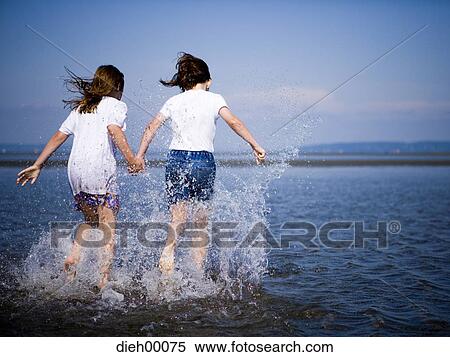 Two female children wading View Large Photo Image Stock Photography - Two female children wading. Fotosearch