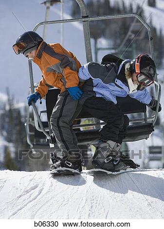Stock Image - Two kids getting off a chairlift. Fotosearch