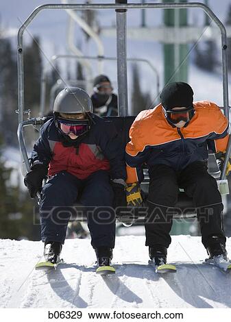 Two kids on a chairlift View Large Photo Image Stock Photo - Two kids on a chairlift. Fotosearch