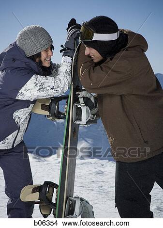 Picture - Two male snowboarders play fighting. Fotosearch