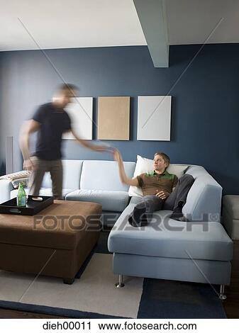 Stock Image - Two men in room. Fotosearch