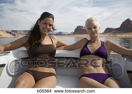 Two women on boat in bikinis smiling View Large Photo Image Picture - Two women on boat in bikinis smiling. Fotosearch