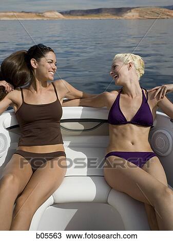 Two women on boat in bikinis smiling View Large Photo Image Stock Image - Two women on boat in bikinis smiling. Fotosearch
