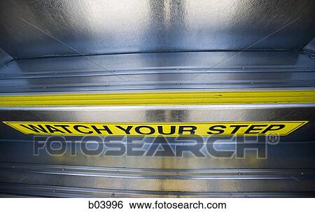 Stock Photograph - Watch your step sign on city bus or subway. Fotosearch