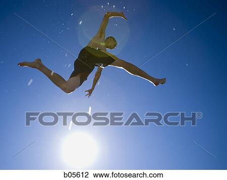 Stock Image - Wet teenage boy diving. Fotosearch