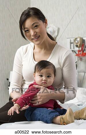 Woman and baby girl in doctor's office View Large Photo Image Stock Image - Woman and baby girl in doctor's office. Fotosearch