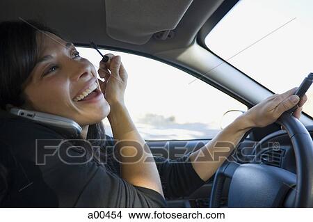 Woman applying mascara in a car View Large Photo Image Picture - Woman applying mascara in a car. Fotosearch