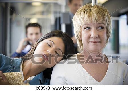 Woman asleep on another woman's shoulder on city bus or subway View Large Photo Image Stock Image - Woman asleep on another woman's shoulder on city bus or subway. Fotosearch