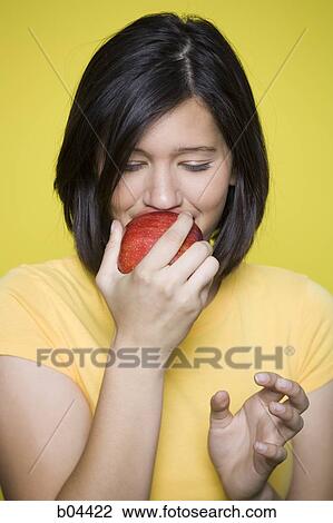 Woman biting into a red apple View Large Photo Image Stock Image - Woman biting into a red apple. Fotosearch