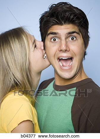 Stock Photo - Woman biting man on cheek. Fotosearch