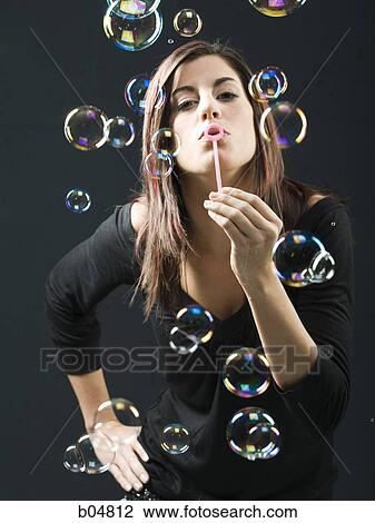 Stock Image - Woman blowing bubbles. Fotosearch