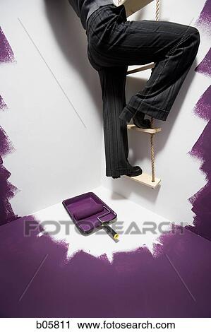 Stock Image - Woman climbing a ladder. Fotosearch