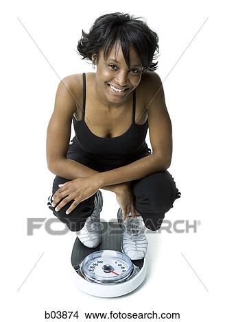 Woman crouching on scale View Large Photo Image Picture - Woman crouching on scale. Fotosearch