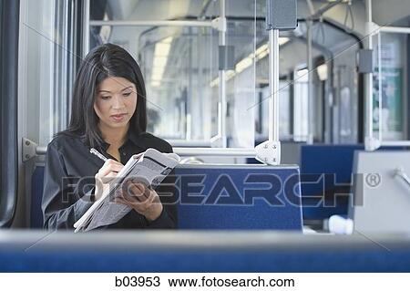 Woman doing crossword on empty bus or subway View Large Photo Image Stock Image - Woman doing crossword on empty bus or subway. Fotosearch