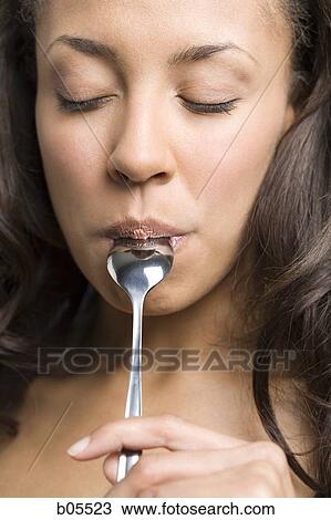 Stock Image - Woman eating with a spoon. Fotosearch