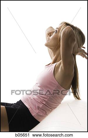 Woman exercising with a pilates ball View Large Photo Image Stock Image - Woman exercising with a pilates ball. Fotosearch