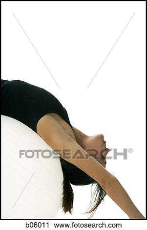 Stock Image - Woman exercising with a pilates ball. Fotosearch