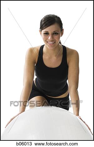 Stock Image - Woman exercising with a pilates ball. Fotosearch