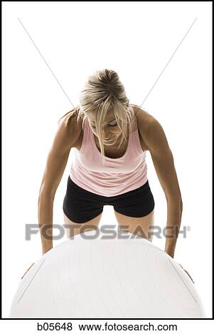Stock Photo - Woman exercising with a pilates ball. Fotosearch
