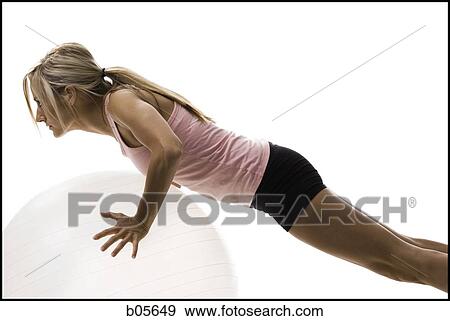 Woman exercising with a pilates ball View Large Photo Image Stock Photo - Woman exercising with a pilates ball. Fotosearch