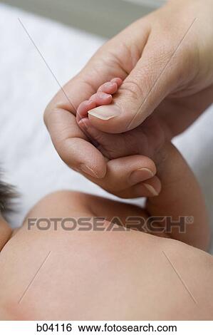 Woman holding baby's hand View Large Photo Image Stock Photograph - Woman holding baby's hand. Fotosearch