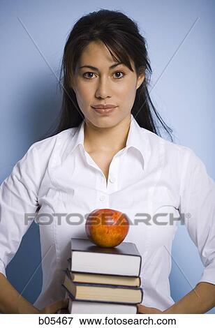 Stock Photo - Woman holding books and red apple. Fotosearch