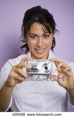 Woman holding digital camera smiling View Large Photo Image Stock Photo - Woman holding digital camera smiling. Fotosearch