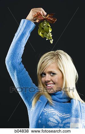 Woman holding mistletoe View Large Photo Image Stock Photo - Woman holding mistletoe. Fotosearch