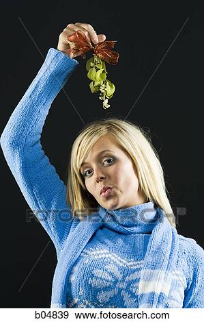 Woman holding mistletoe View Large Photo Image Stock Photo - Woman holding mistletoe. Fotosearch