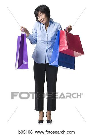 Woman holding shopping bags View Large Photo Image Stock Photo - Woman holding shopping bags. Fotosearch