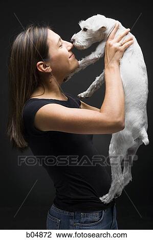 Woman holding white dog smiling View Large Photo Image Stock Image - Woman holding white dog smiling. Fotosearch