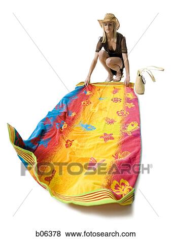 Stock Photo - Woman in beachwear laying down a towel. Fotosearch