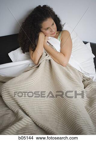 Woman in bed hugging blanket View Large Photo Image Picture - Woman in bed hugging blanket. Fotosearch