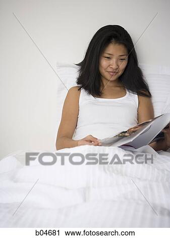 Woman in bed with magazine View Large Photo Image Stock Image - Woman in bed with magazine. Fotosearch