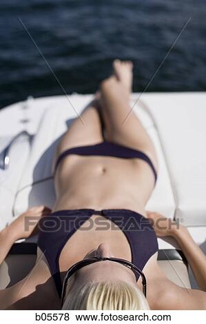 Woman in bikini sunbathing on boat View Large Photo Image Stock Photo - Woman in bikini sunbathing on boat. Fotosearch