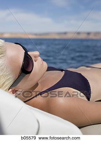 Woman in bikini sunbathing on boat View Large Photo Image Stock Photo - Woman in bikini sunbathing on boat. Fotosearch