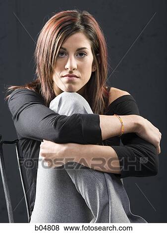 Woman in chair leaning on knee View Large Photo Image Stock Photo - Woman in chair leaning on knee. Fotosearch