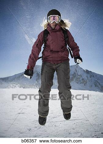 Stock Photo - Woman jumping outside in the snow. Fotosearch