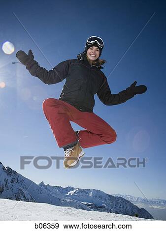 Woman jumping outside in the snow View Large Photo Image Stock Photo - Woman jumping outside in the snow. Fotosearch
